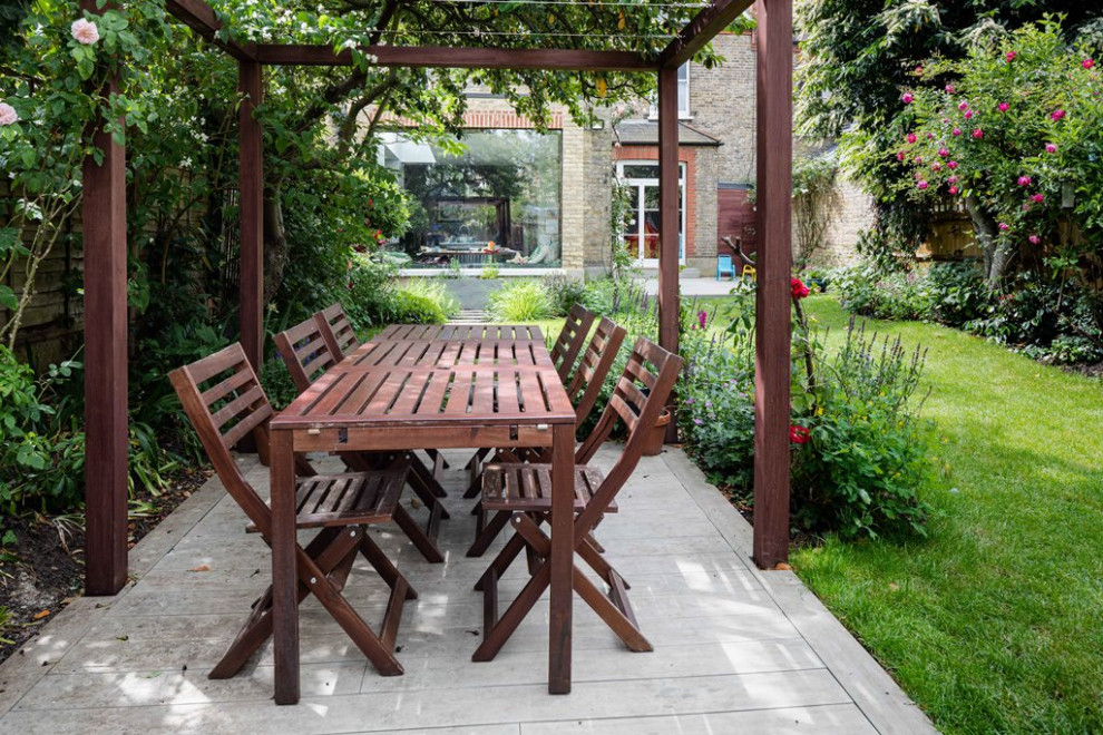 This is an example of a mid-sized contemporary backyard patio in London with decking.