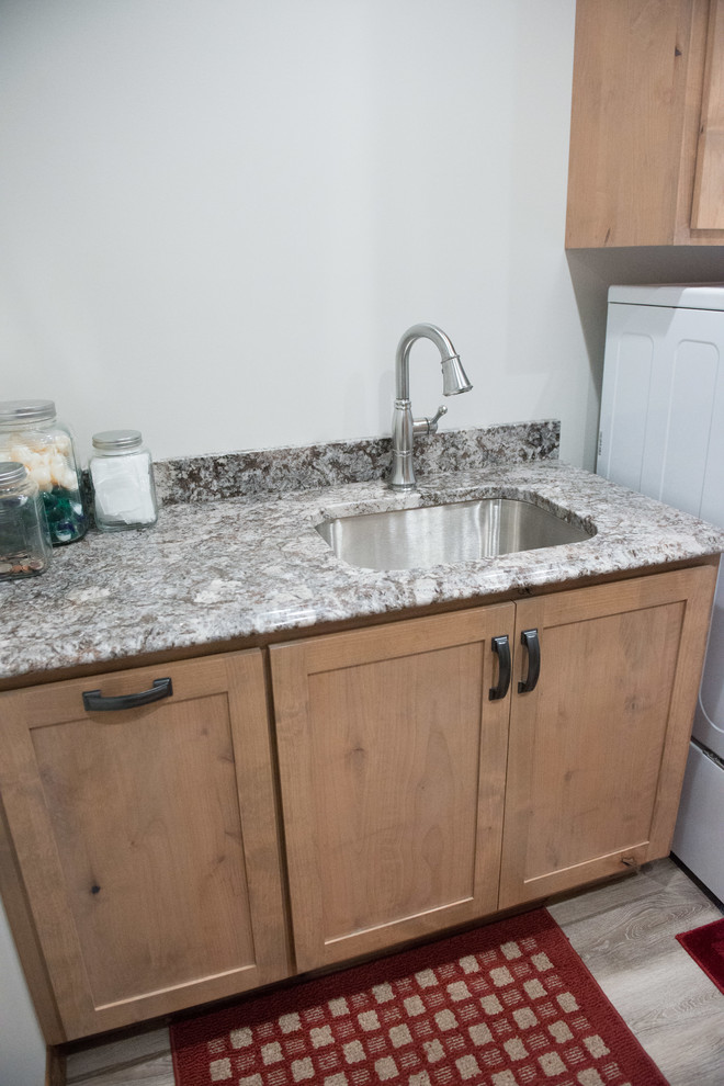 Inspiration for a large rustic u-shaped laminate floor utility room remodel with an undermount sink, shaker cabinets, light wood cabinets, granite countertops, white walls, a side-by-side washer/dryer and multicolored countertops