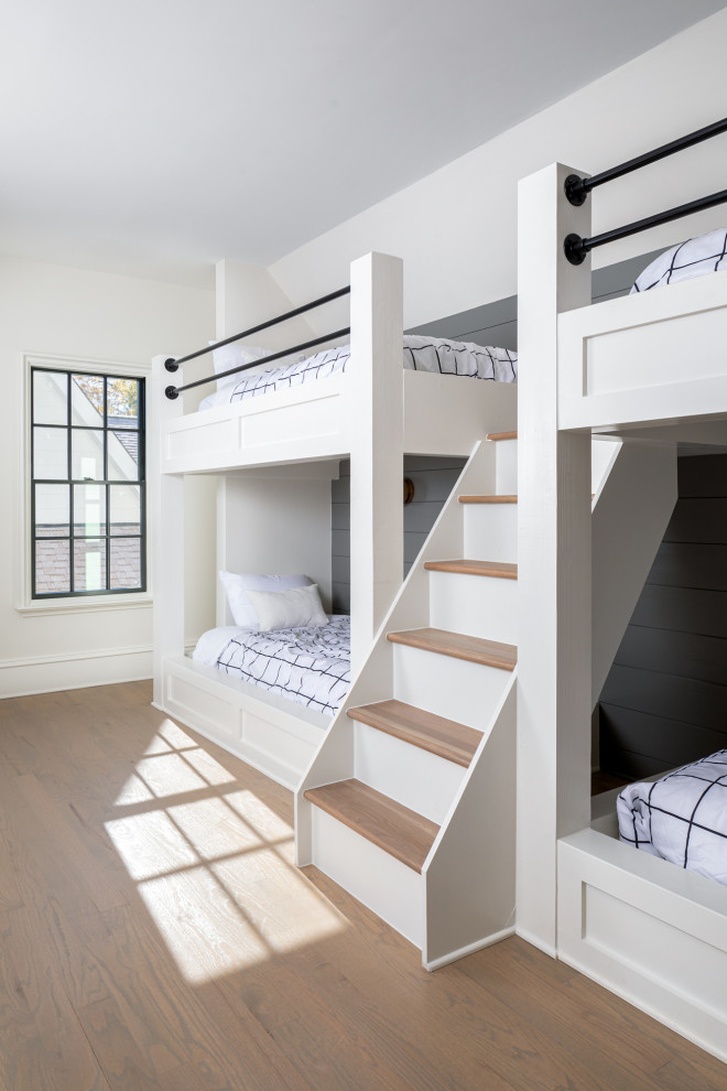 Foto de dormitorio infantil minimalista extra grande con paredes blancas, suelo de madera clara y suelo marrón