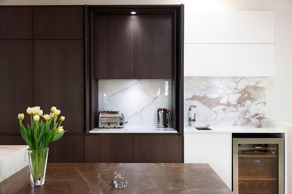 Large modern single-wall open plan kitchen in Sydney with a single-bowl sink, flat-panel cabinets, dark wood cabinets, marble benchtops, multi-coloured splashback, stainless steel appliances, travertine floors, multiple islands and stone slab splashback.