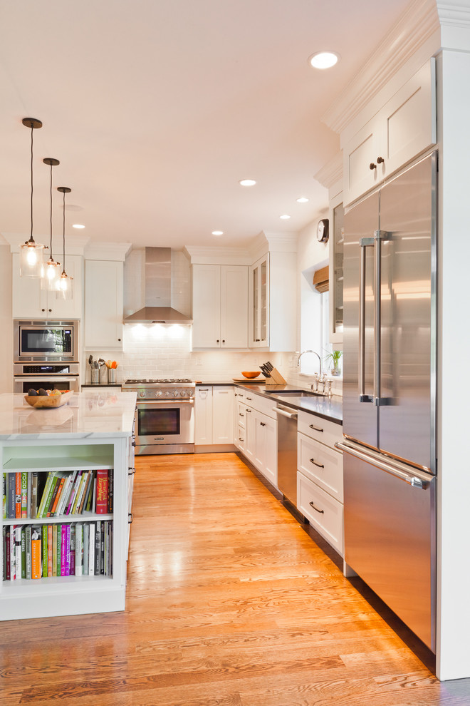 Photo of a traditional kitchen in Boston with an undermount sink, shaker cabinets, white cabinets, white splashback, subway tile splashback and stainless steel appliances.