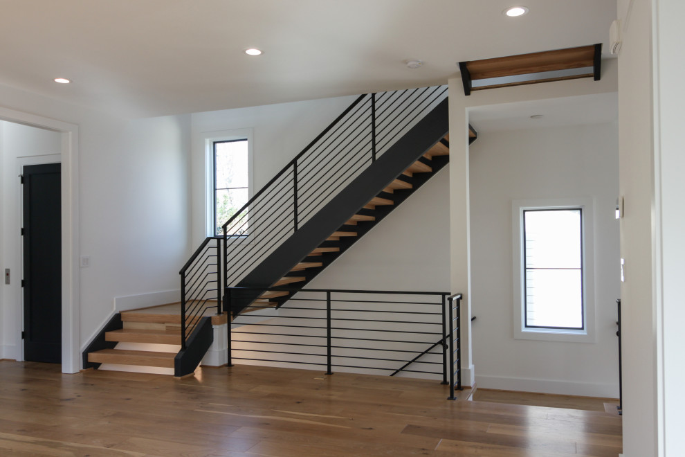 На фото: прямая лестница среднего размера в современном стиле с деревянными ступенями и металлическими перилами