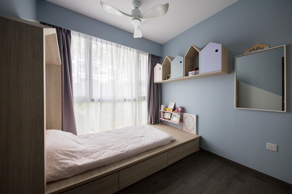 Scandinavian kids' bedroom in Singapore with blue walls, dark hardwood floors and brown floor for kids 4-10 years old and girls.