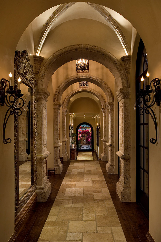 Inspiration for an expansive mediterranean hallway in Phoenix with beige walls and travertine floors.