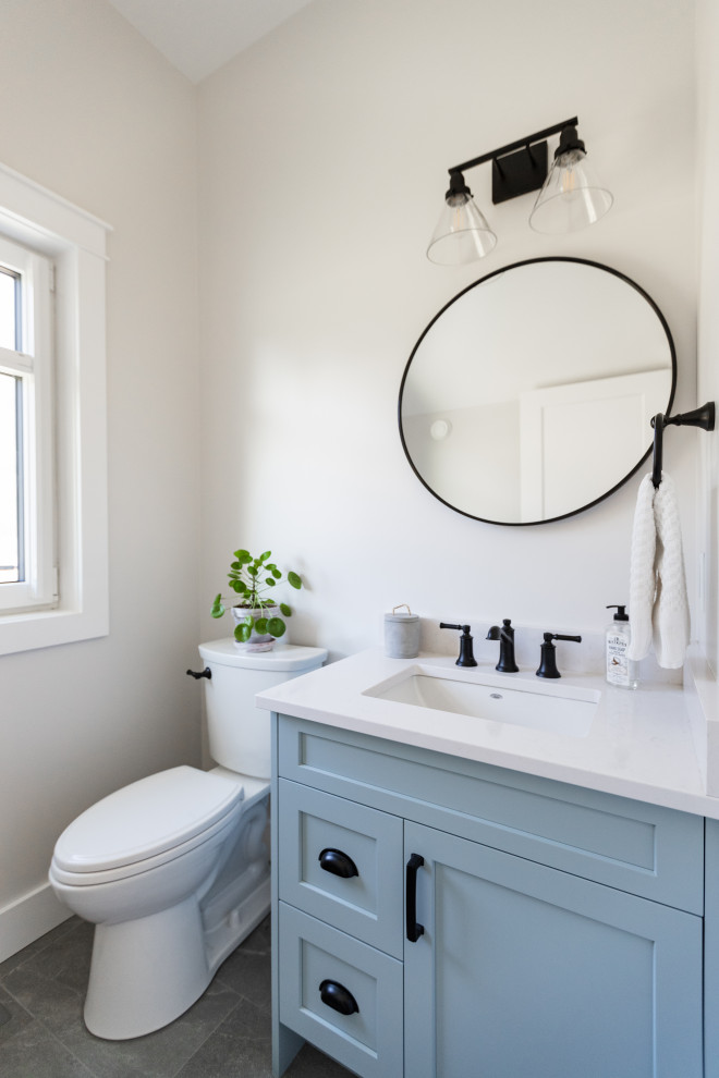 Design ideas for a traditional cloakroom in Vancouver with shaker cabinets, blue cabinets, porcelain flooring, a submerged sink, engineered stone worktops, grey floors, white worktops and a built in vanity unit.