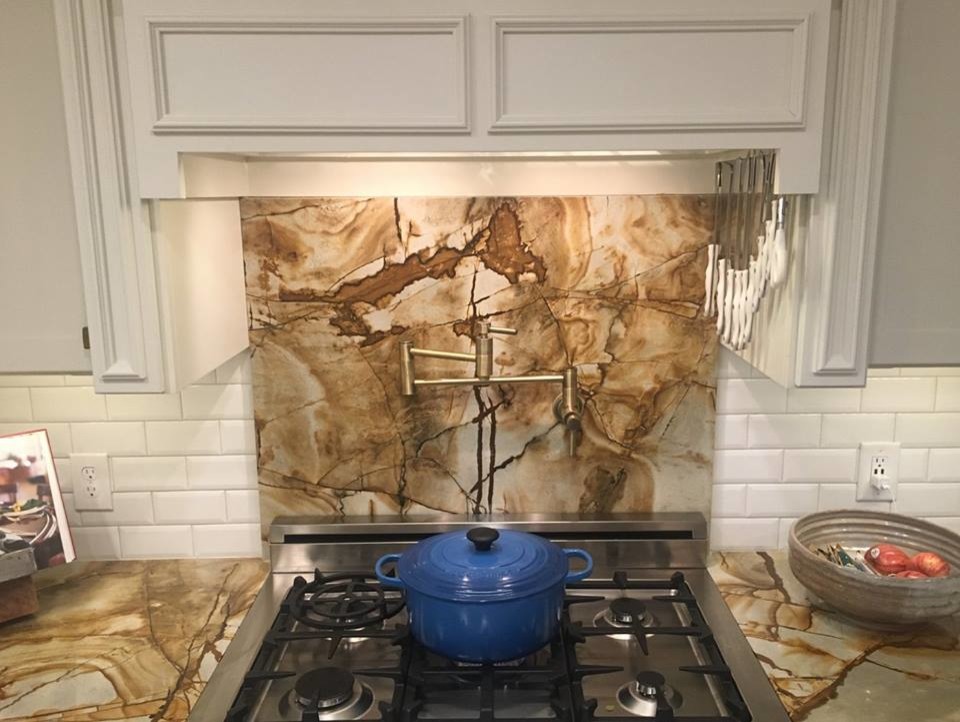 Kitchen - mid-sized kitchen idea in Atlanta with a farmhouse sink, granite countertops, white backsplash, ceramic backsplash, stainless steel appliances and an island