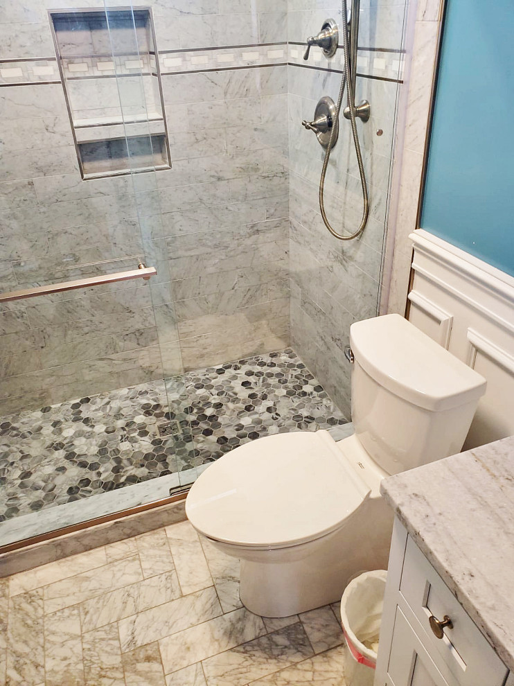 Kleines Modernes Badezimmer mit weißen Schränken, Toilette mit Aufsatzspülkasten, grauen Fliesen, Marmorfliesen, blauer Wandfarbe, Marmorboden, grauem Boden, Schiebetür-Duschabtrennung, weißer Waschtischplatte, Duschbank, Einzelwaschbecken und vertäfelten Wänden in Boston