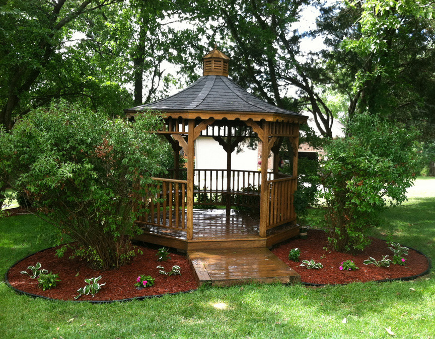 This is an example of a mid-sized transitional full sun backyard landscaping for spring.