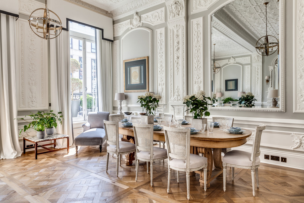 Traditional dining room in London with grey walls and medium hardwood floors.