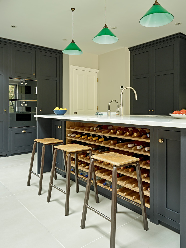 This is an example of a large transitional eat-in kitchen in London with shaker cabinets, black cabinets, solid surface benchtops, grey splashback, porcelain floors, with island and grey floor.