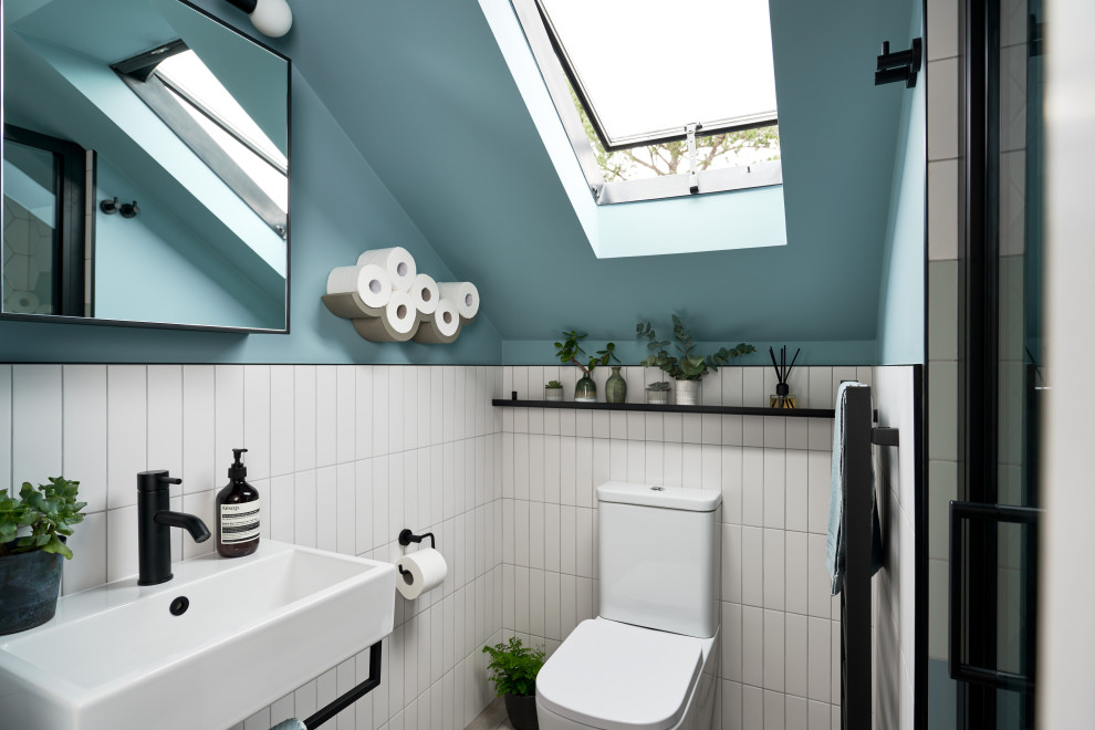Imagen de cuarto de baño único contemporáneo pequeño con ducha empotrada, baldosas y/o azulejos azules, paredes azules, aseo y ducha, lavabo suspendido, suelo marrón y ducha con puerta con bisagras