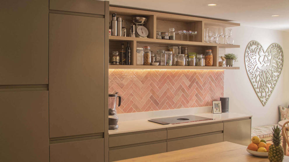 Inspiration pour une cuisine américaine design en L et bois clair de taille moyenne avec un placard à porte plane, un plan de travail en quartz, une crédence rose, une crédence en terre cuite, îlot et un plan de travail blanc.