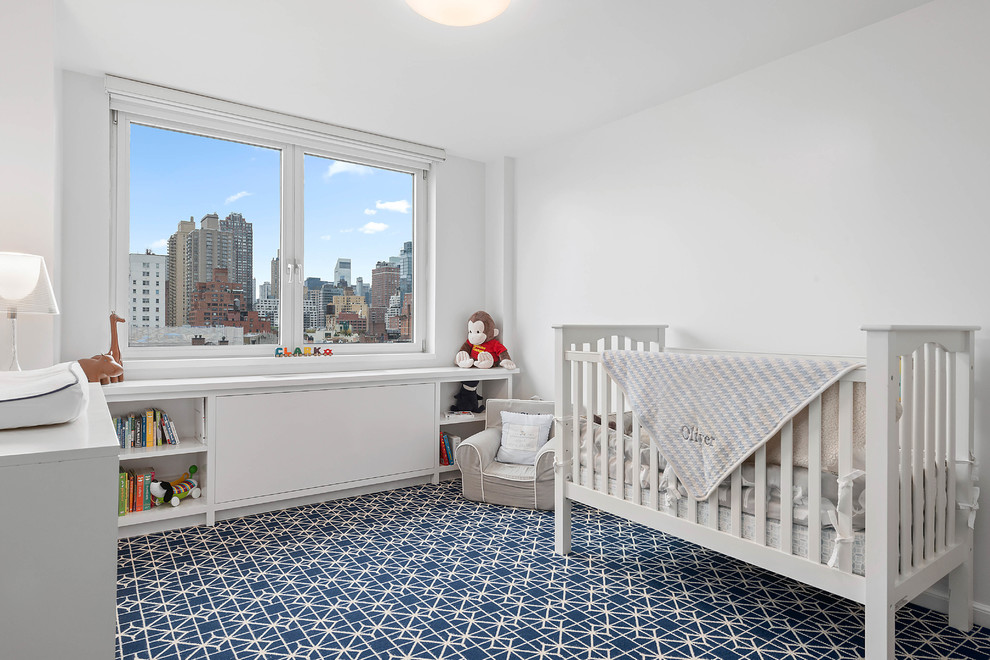 Design ideas for a mid-sized transitional nursery for boys in New York with white walls, carpet and blue floor.