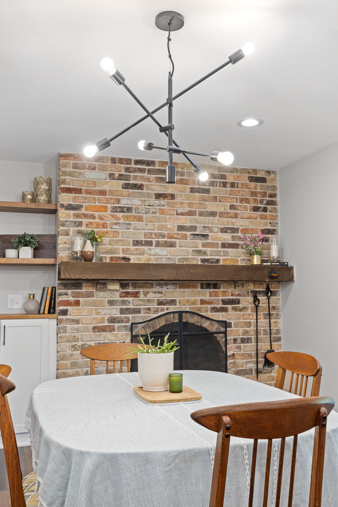 Идея дизайна: большая кухня-столовая в стиле неоклассика (современная классика) с серыми стенами, полом из винила, стандартным камином, фасадом камина из кирпича и коричневым полом