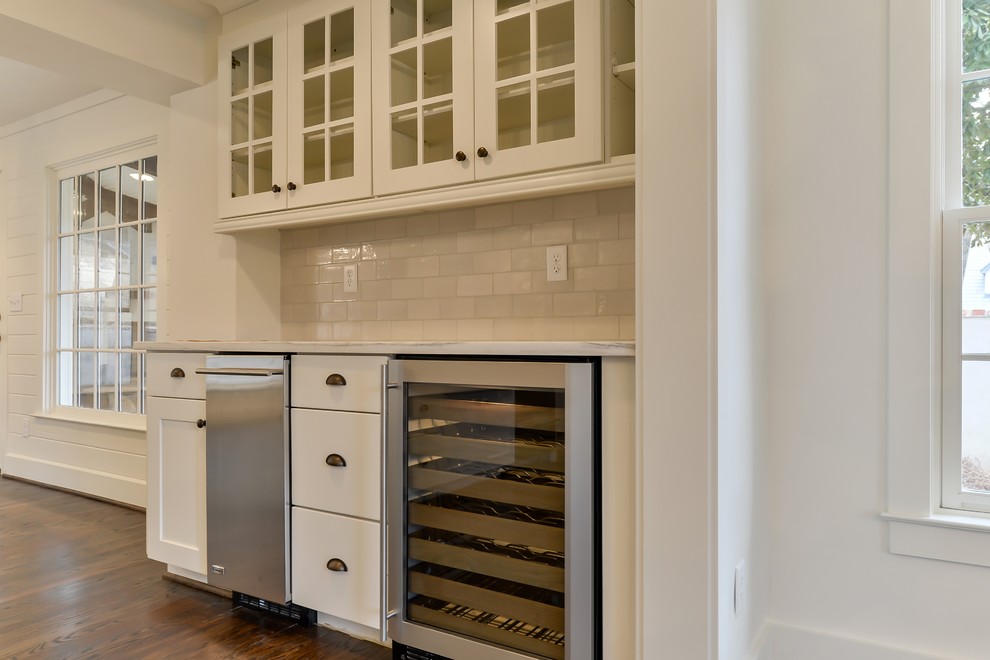 Open concept kitchen - large transitional single-wall dark wood floor open concept kitchen idea in Birmingham with a farmhouse sink, shaker cabinets, white cabinets, white backsplash, stainless steel appliances, an island and marble countertops