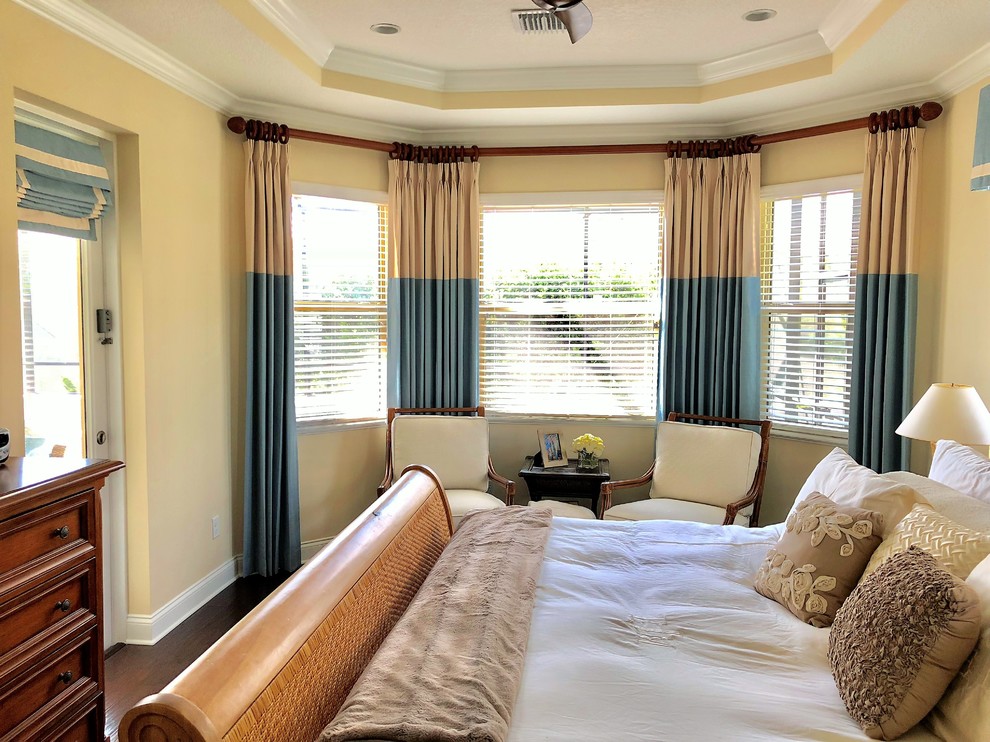 Design ideas for a tropical master bedroom in Orlando with brown floor.