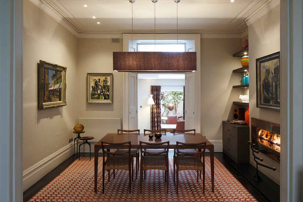 This is an example of a mid-sized traditional separate dining room in London with grey walls and a corner fireplace.