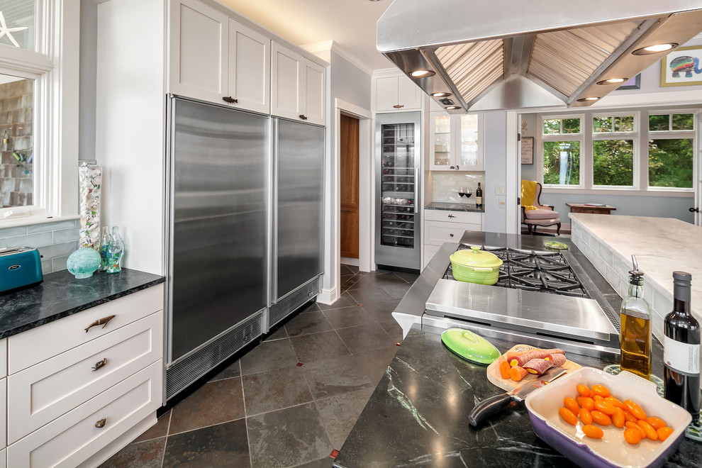 This is an example of a large beach style open plan kitchen in Seattle with an undermount sink, shaker cabinets, soapstone benchtops, glass tile splashback, stainless steel appliances, slate floors, with island, green floor and green benchtop.