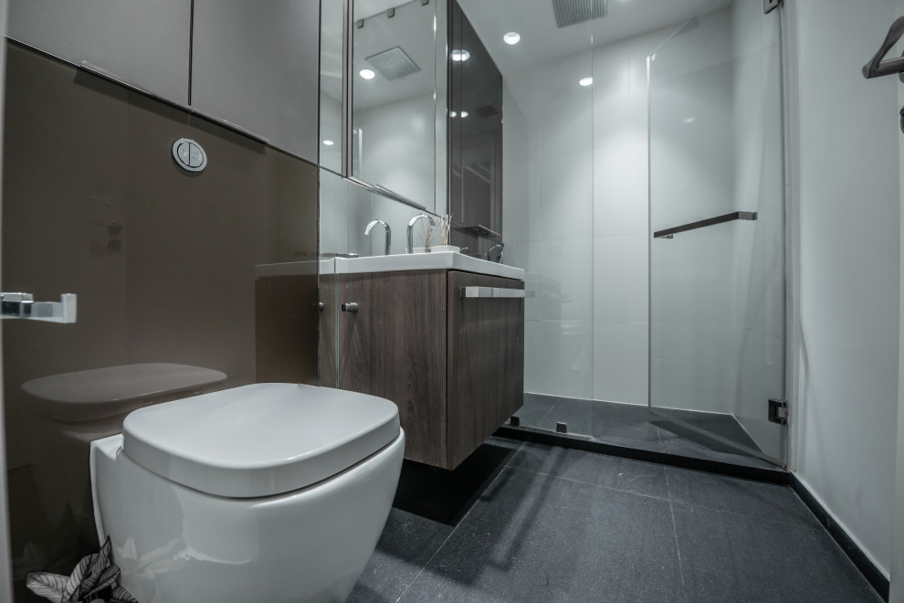 This is an example of a small modern kids bathroom in San Francisco with flat-panel cabinets, grey cabinets, an alcove shower, a wall-mount toilet, white tile, ceramic tile, white walls, a drop-in sink, solid surface benchtops, a hinged shower door, white benchtops, a single vanity, a floating vanity and panelled walls.