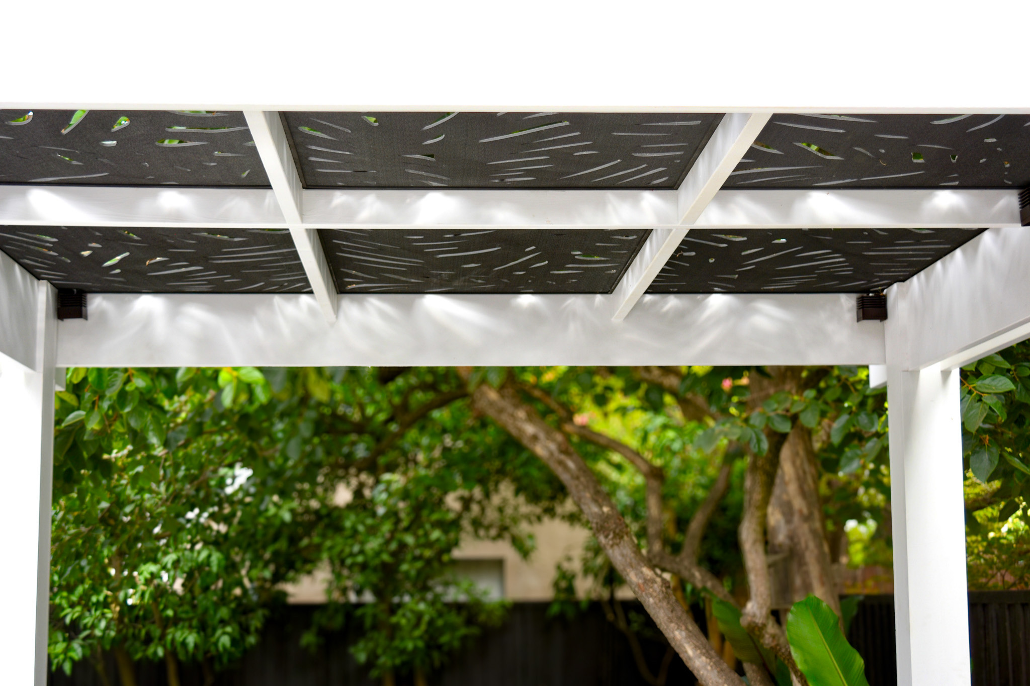 Under the Custom-Designed Pergola: Tropical Cut-Out Trellis and Ambient Lighting