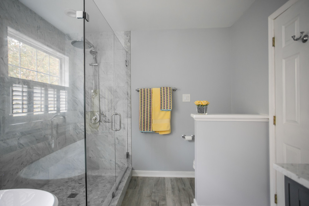 Mid-sized transitional master bathroom in Richmond with flat-panel cabinets, grey cabinets, a freestanding tub, a corner shower, gray tile, marble, grey walls, wood-look tile, a drop-in sink, marble benchtops, a sliding shower screen, grey benchtops, a double vanity and a floating vanity.