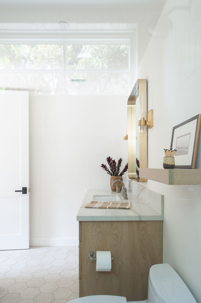 This is an example of a mid-sized modern bathroom in San Diego with flat-panel cabinets, light wood cabinets, a corner shower, white tile, terra-cotta tile, an undermount sink, engineered quartz benchtops, a hinged shower door and white benchtops.