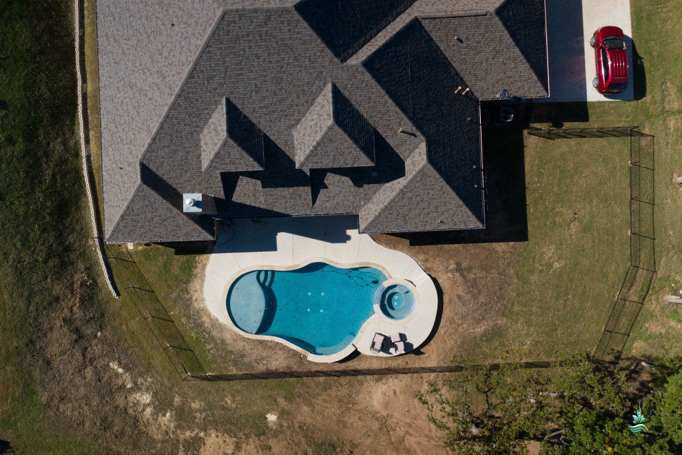 Großer Mediterraner Pool hinter dem Haus in individueller Form mit Betonplatten in Dallas