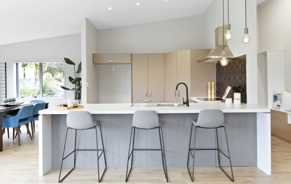 Große Moderne Wohnküche in U-Form mit Küchenrückwand in Schwarz, Laminat, Halbinsel, beigem Boden und weißer Arbeitsplatte in Auckland
