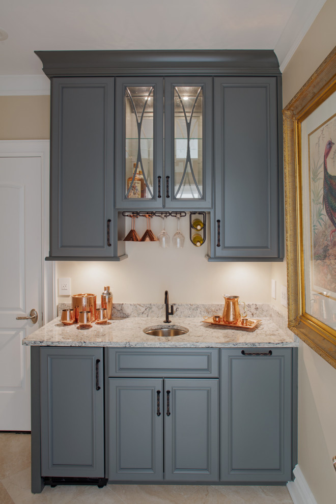 Small transitional single-wall wet bar in Charleston with raised-panel cabinets, grey cabinets, grey splashback, porcelain floors, beige floor and grey benchtop.