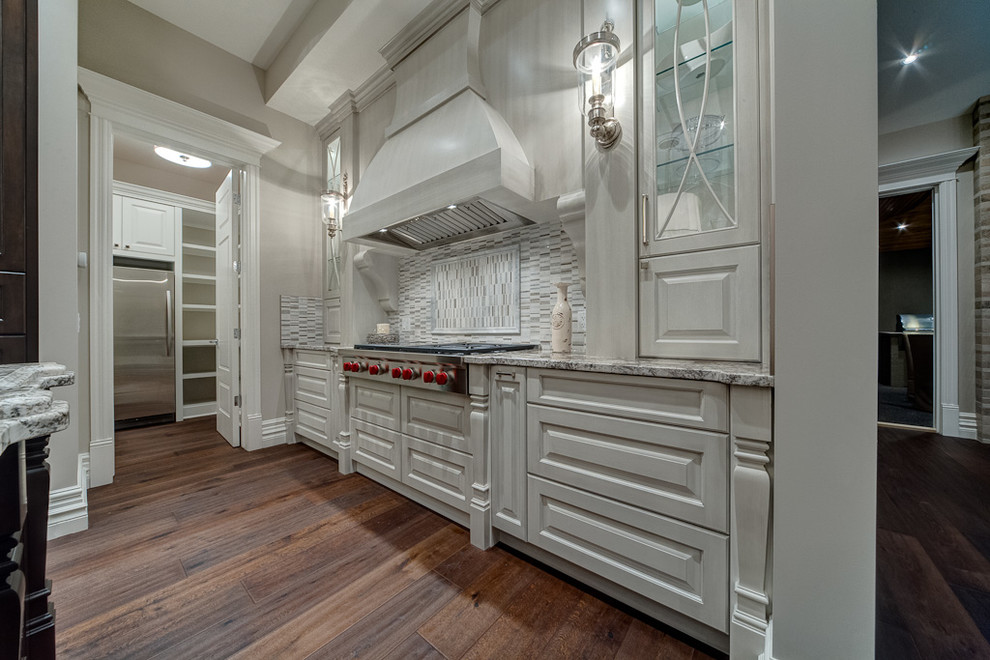 Inspiration for a transitional medium tone wood floor kitchen remodel in Calgary with raised-panel cabinets, distressed cabinets, stainless steel appliances and an island