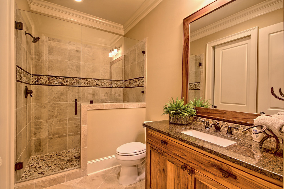 Small country 3/4 bathroom in Atlanta with recessed-panel cabinets, light wood cabinets, an alcove shower, a two-piece toilet, multi-coloured tile, mosaic tile, beige walls, travertine floors, an undermount sink and granite benchtops.