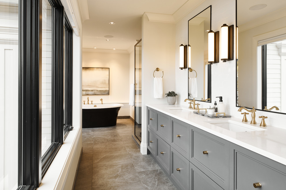 Inspiration for a large transitional master bathroom in Vancouver with grey cabinets, a freestanding tub, white walls, porcelain floors, an undermount sink, quartzite benchtops, grey floor, white benchtops and recessed-panel cabinets.