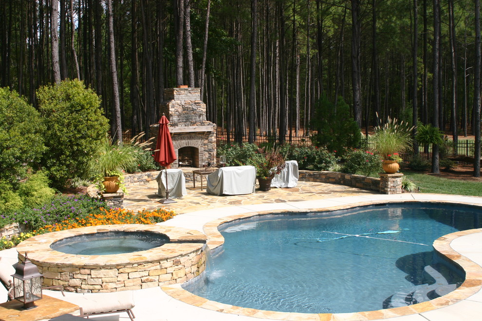 Hot tub - large rustic backyard concrete paver and custom-shaped lap hot tub idea in Charlotte