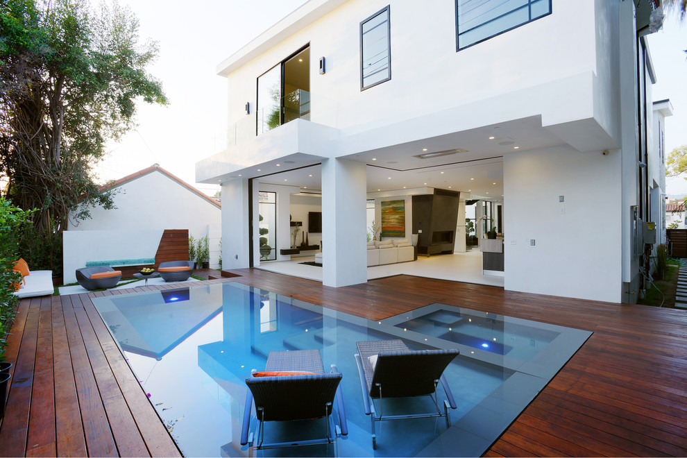 Inspiration for a large contemporary backyard rectangular lap pool in Los Angeles with a hot tub and decking.