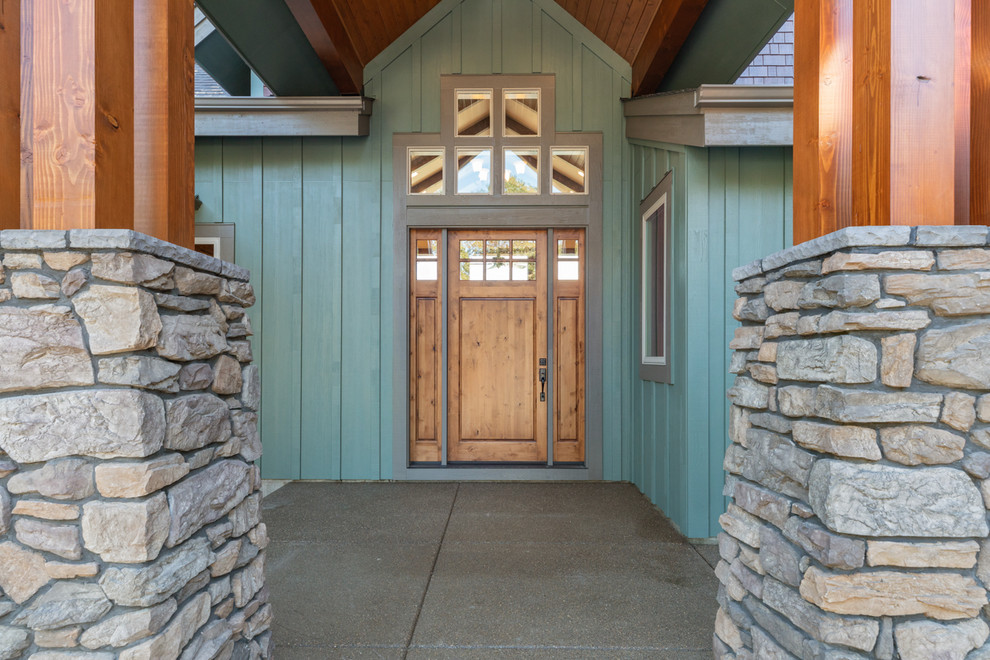 Large craftsman green two-story wood house exterior idea with a shingle roof