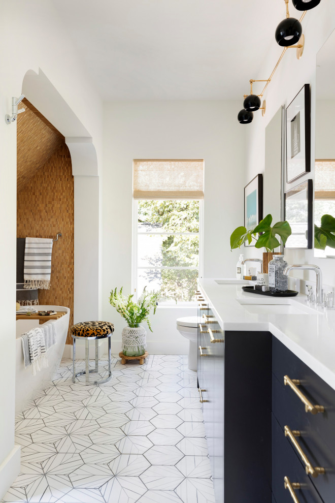 Eclectic master bathroom in Minneapolis with flat-panel cabinets, blue cabinets, a freestanding tub, white walls, porcelain floors, an undermount sink, solid surface benchtops, white floor, white benchtops and a double vanity.