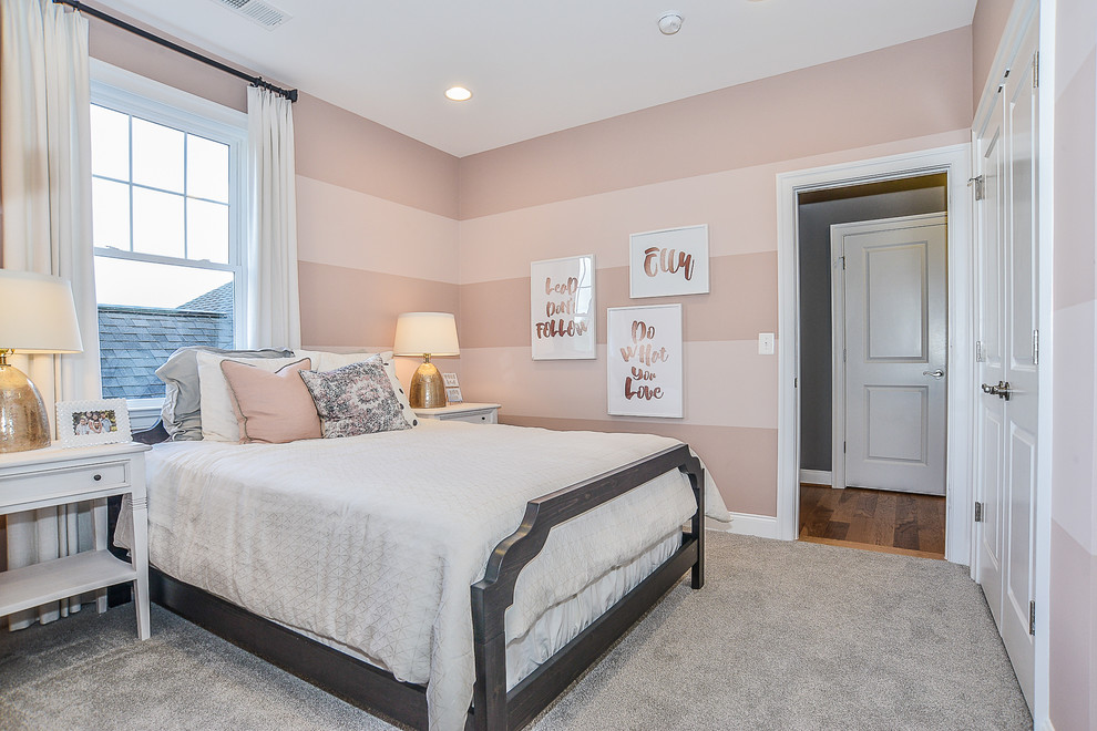 This is an example of a mid-sized transitional kids' room for girls in DC Metro with pink walls and carpet.