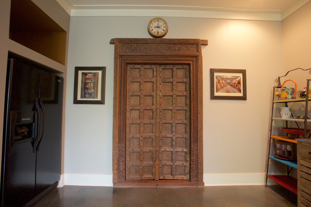 Mid-sized transitional walk-out concrete floor home design photo with beige walls and no fireplace