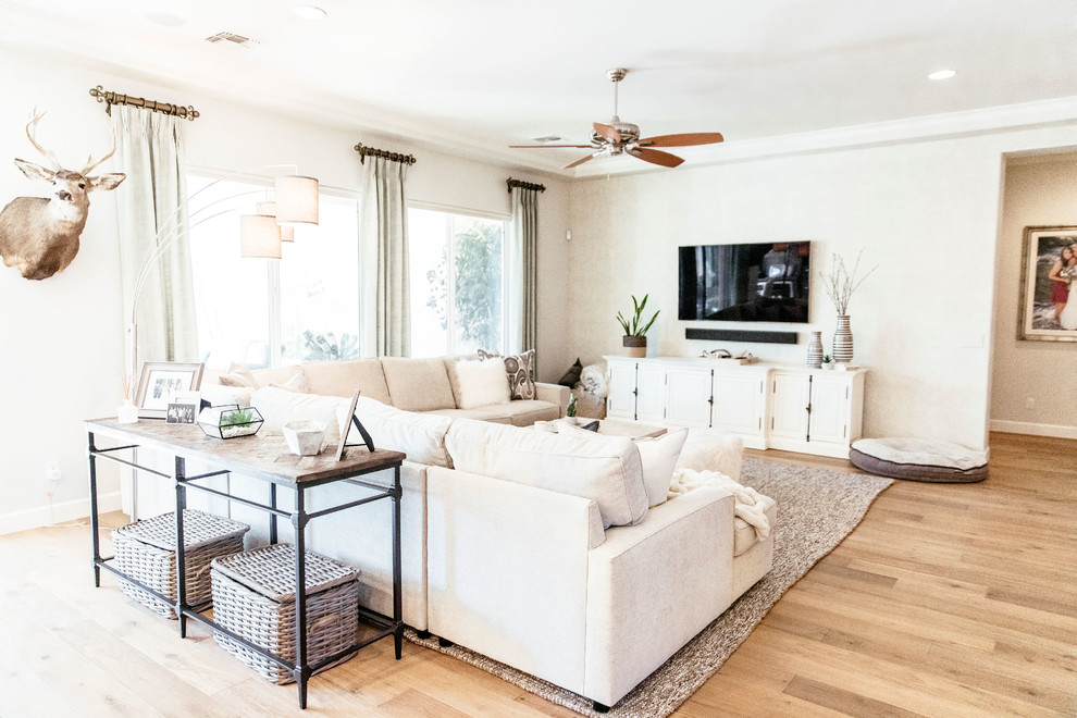 This is an example of a mid-sized contemporary formal open concept living room in Phoenix with beige walls, light hardwood floors, no fireplace, a wall-mounted tv and beige floor.