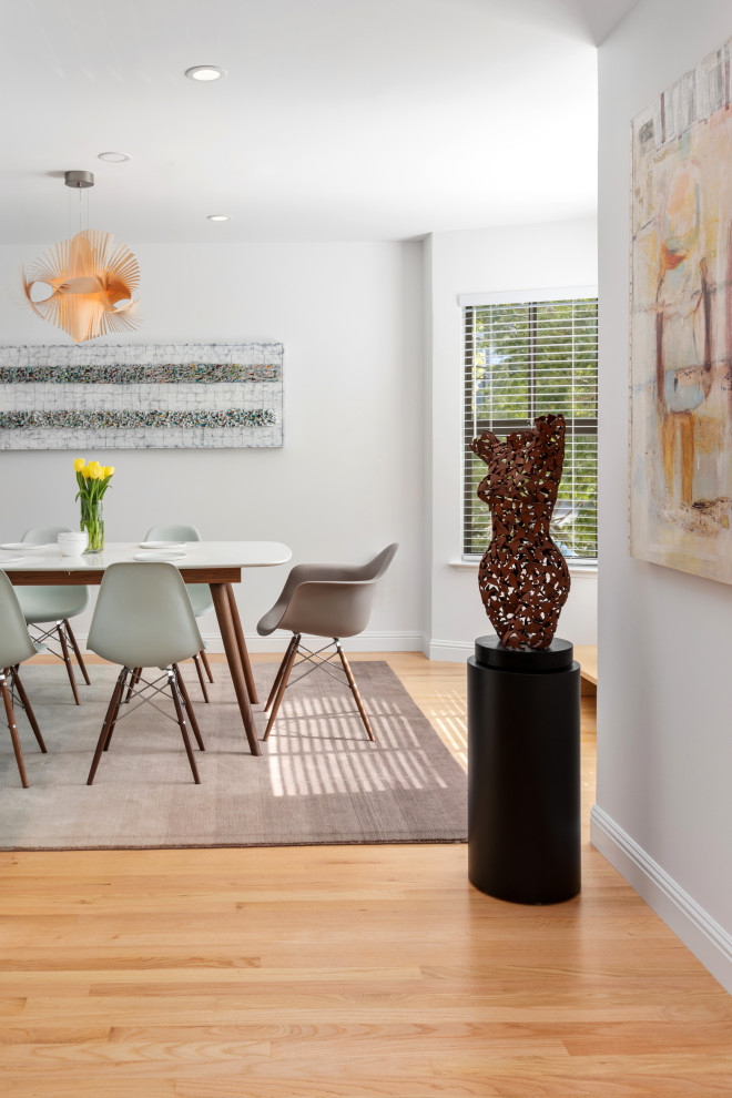 Immagine di una sala da pranzo aperta verso la cucina moderna di medie dimensioni con pareti grigie, parquet chiaro e pavimento marrone