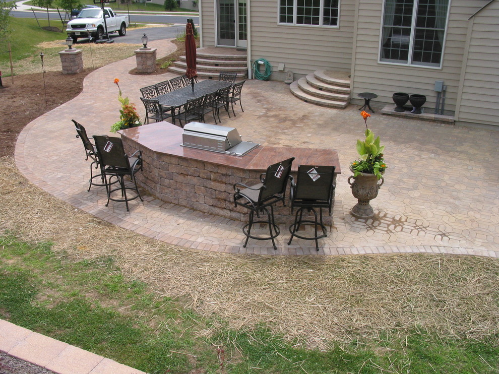 This is an example of a mid-sized traditional backyard patio in Baltimore with an outdoor kitchen, concrete pavers and no cover.