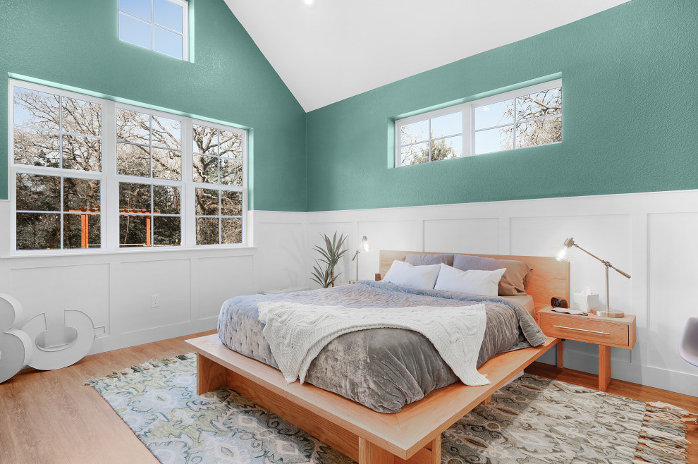 Aménagement d'une grande chambre parentale campagne avec un mur blanc, un sol en bois brun, un sol marron et un plafond voûté.