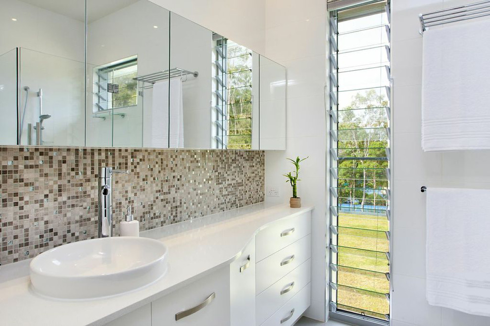 Inspiration for a mid-sized contemporary kids bathroom in Sunshine Coast with flat-panel cabinets, white cabinets, engineered quartz benchtops, multi-coloured tile, mosaic tile, white walls and ceramic floors.