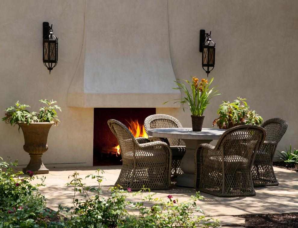 Design ideas for a large mediterranean backyard patio in Santa Barbara with natural stone pavers and no cover.