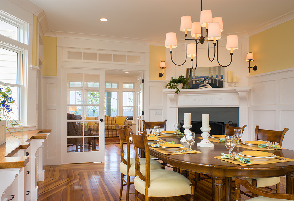 Design ideas for a traditional dining room in Providence with a corner fireplace and yellow walls.