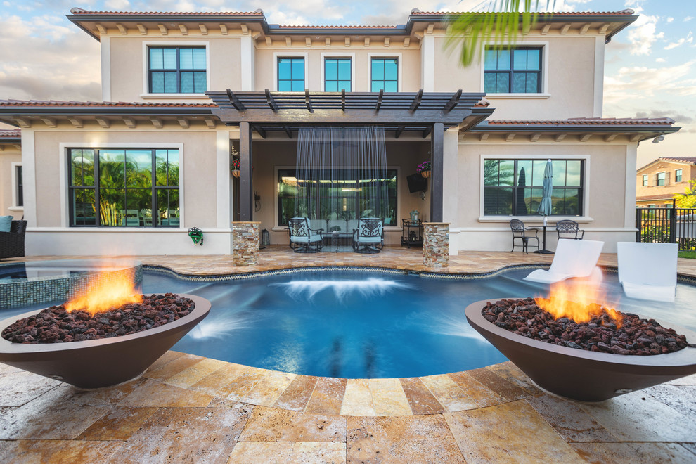 Design ideas for a large arts and crafts backyard custom-shaped pool in Miami with a water feature and natural stone pavers.