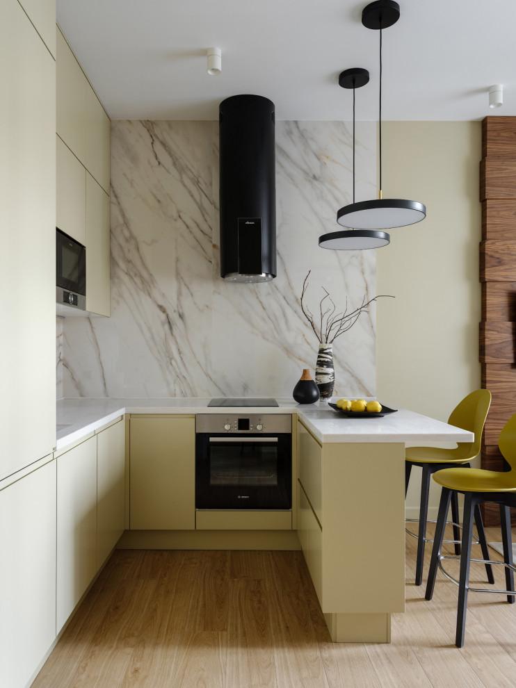 Inspiration for a small contemporary u-shaped kitchen/diner in Moscow with flat-panel cabinets, beige cabinets, composite countertops, white splashback, porcelain splashback, black appliances, medium hardwood flooring, beige floors and white worktops.