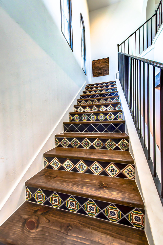 Inspiration for a small wood l-shaped staircase in Austin with tile risers and metal railing.