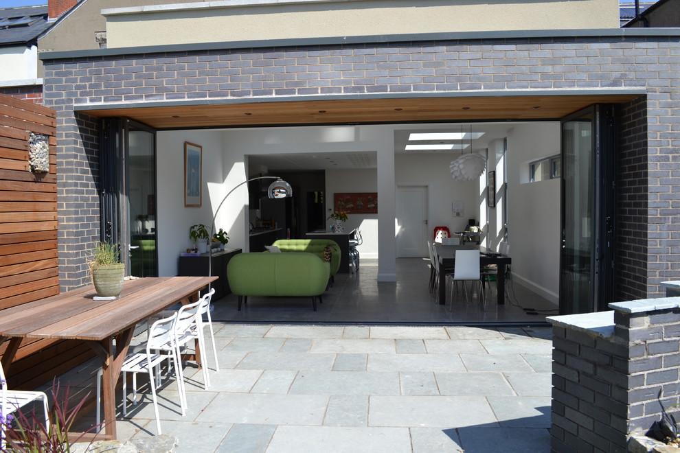 Design ideas for a Medium Sized modern Back patio in Dublin With a Roof Extension.