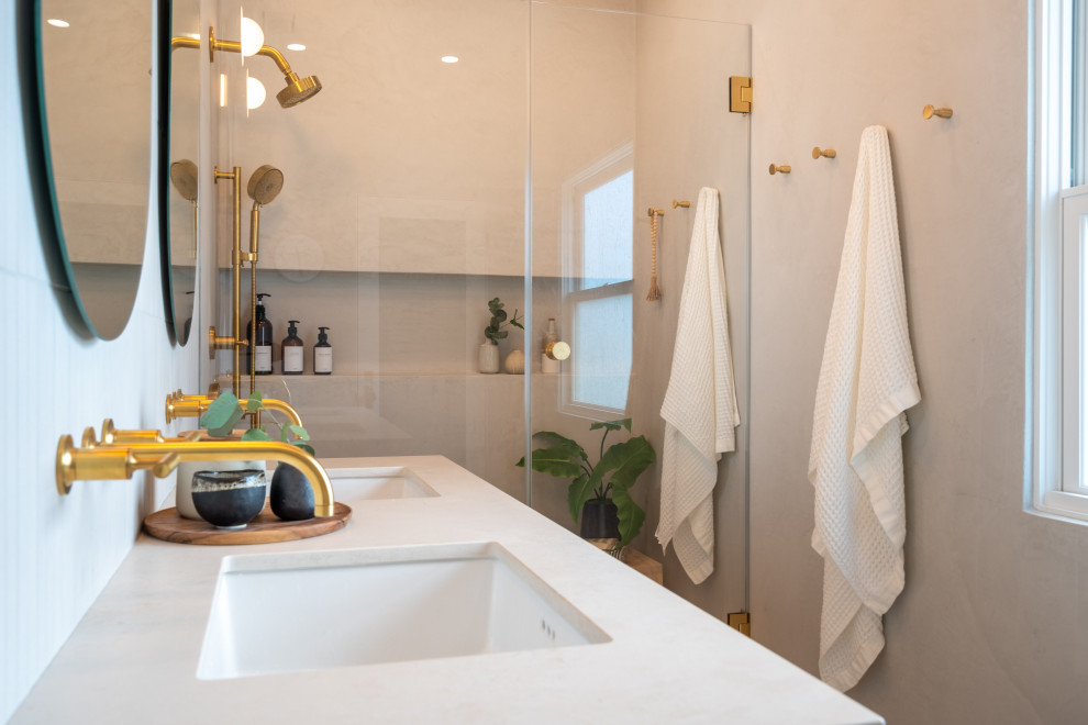 Exempel på ett mellanstort minimalistiskt beige beige en-suite badrum, med släta luckor, en dusch i en alkov, en vägghängd toalettstol, beige kakel, kakelplattor, beige väggar, klinkergolv i keramik, ett undermonterad handfat, bänkskiva i kvarts, beiget golv och dusch med gångjärnsdörr